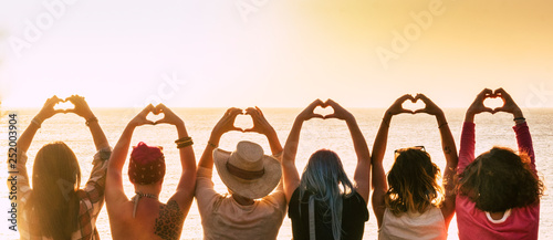 Group of diversity alternative young woman enjoying the sunset at the sea doing hearth symbol with hands - people enjoying friendly lifestyle - vacation in friendship concept for females #252003904