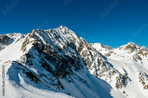 Schneebedeckter Gipfel unter blauem Himmel in den österreichischen Bergen im Winter