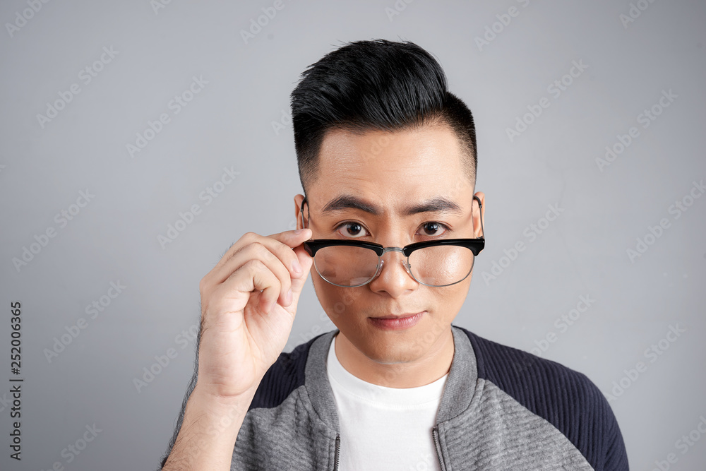Portrait of shocked modern man touching his spectacles Portrait of shocked modern man touching his spectacles