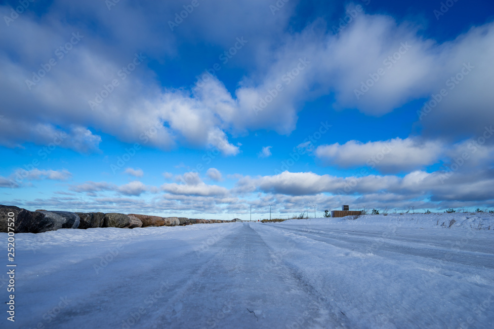 Beautiful snowy road in winter under blue sky