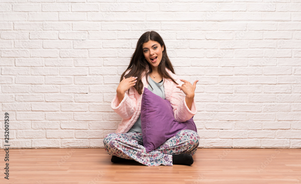 Teenager girl in pajamas with surprise facial expression