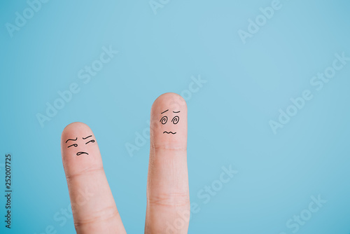 cropped view of dissatisfied fingers isolated on blue