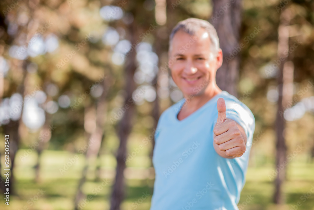 Happy mature business man showing thumbs up sign