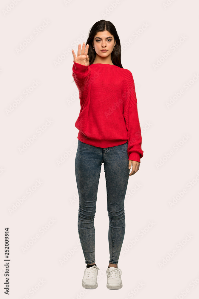 A full-length shot of a Teenager girl with red sweater making stop gesture denying a situation that thinks wrong over isolated background A full-length shot of a Teenager girl with red sweater making stop gesture denying a situation that thinks wrong over isolated background