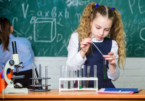 Chemical analysis. School pupil study chemical liquids. School chemistry lesson. Test tubes with substances. Laboratory glassware. School laboratory. Girl smart student conduct school experiment