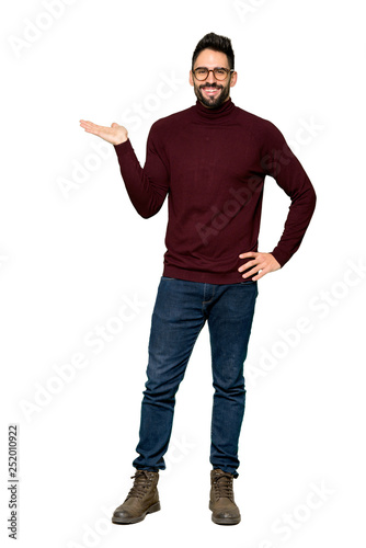 Full-length shot of Handsome man with glasses holding copyspace imaginary on the palm to insert an ad on isolated white background