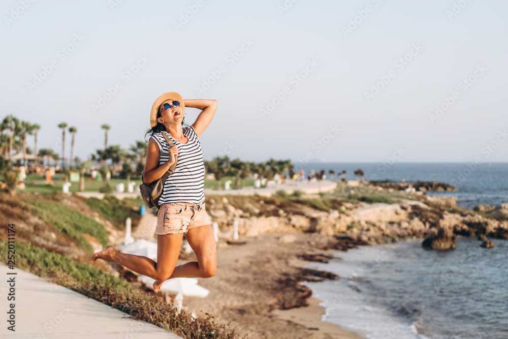 Cute tourist pan asian girl jumping outdoor near sea. Cute tourist pan asian girl jumping outdoor near sea.