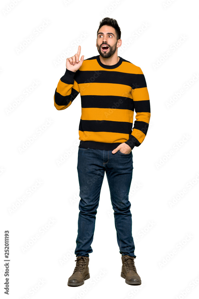 Full-length shot of Handsome man with striped sweater thinking an idea pointing the finger up on isolated white background Full-length shot of Handsome man with striped sweater thinking an idea pointing the finger up on isolated white background
