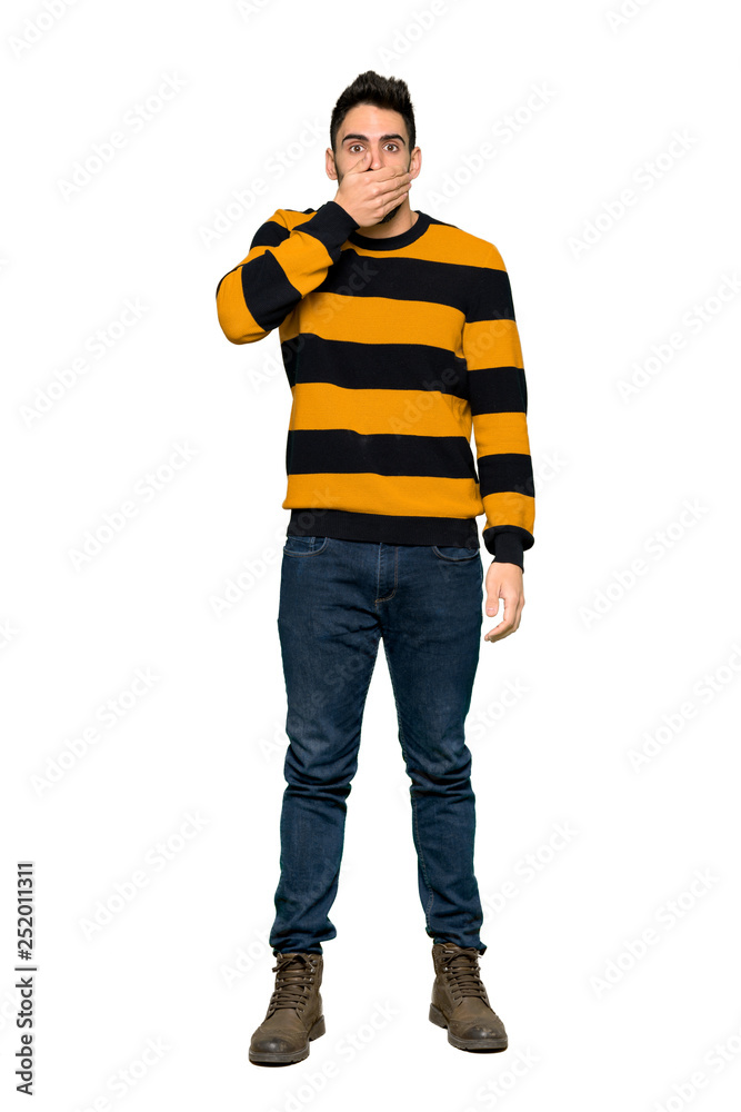 Full-length shot of Handsome man with striped sweater covering mouth with hands for saying something inappropriate on isolated white background Full-length shot of Handsome man with striped sweater covering mouth with hands for saying something inappropriate on isolated white background