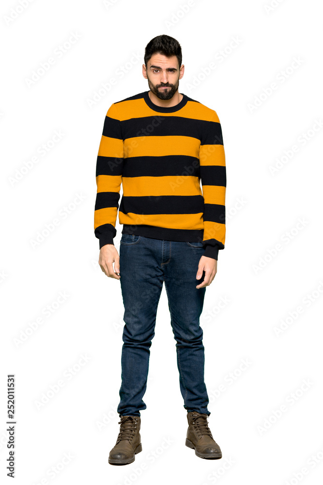 Full-length shot of Handsome man with striped sweater with sad and depressed expression on isolated white background Full-length shot of Handsome man with striped sweater with sad and depressed expression on isolated white background
