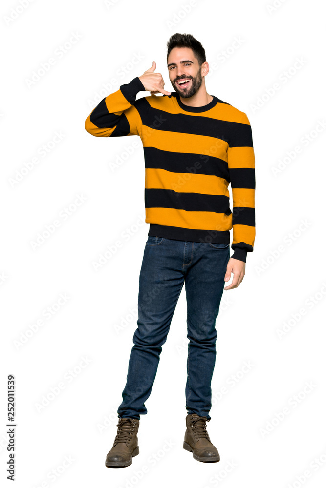 Full-length shot of Handsome man with striped sweater making phone gesture. Call me back sign on isolated white background Full-length shot of Handsome man with striped sweater making phone gesture. Call me back sign on isolated white background