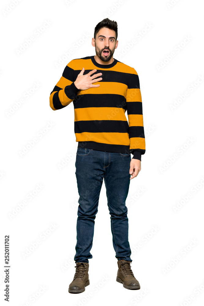 Full-length shot of Handsome man with striped sweater surprised and shocked while looking right on isolated white background Full-length shot of Handsome man with striped sweater surprised and shocked while looking right on isolated white background
