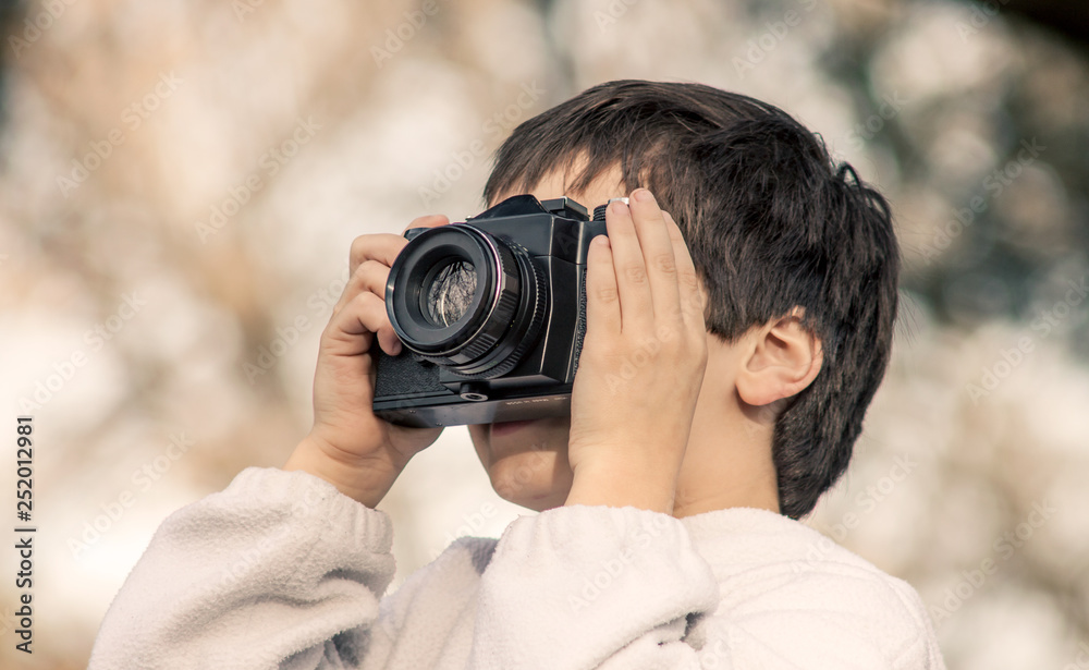 young boy with a camera taking a picture image photography course lesson teach class shooting video recording 