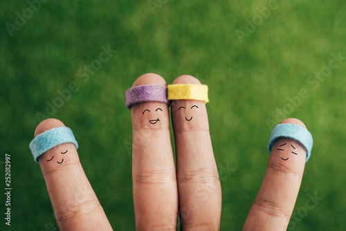 cropped view of cheerful sporty fingers in headbands on green