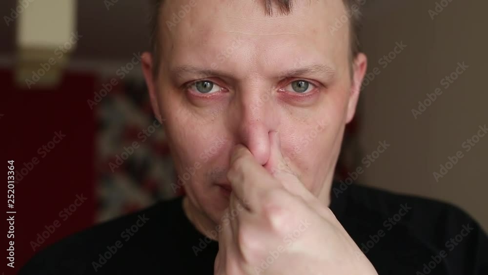 painful looking man splashes a medicine in runny nose. nasal spray, close-up painful looking man splashes a medicine in runny nose. nasal spray, close-up
