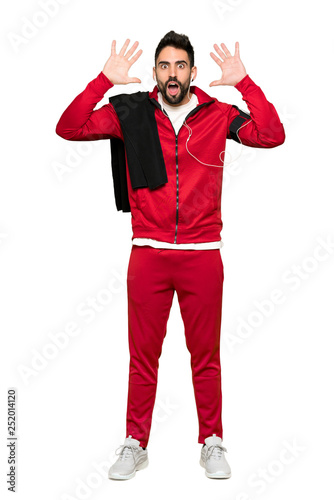 Full-length shot of Handsome sportman with surprise and shocked facial expression on isolated white background