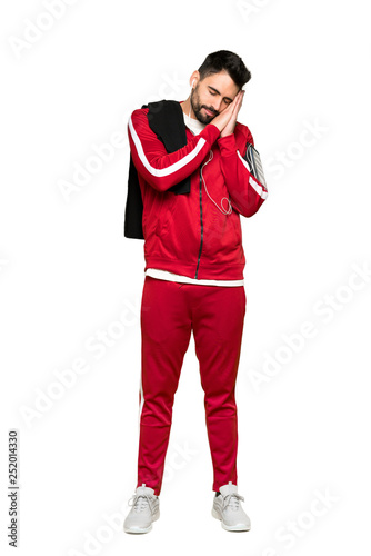 Full-length shot of Handsome sportman making sleep gesture in dorable expression on isolated white background