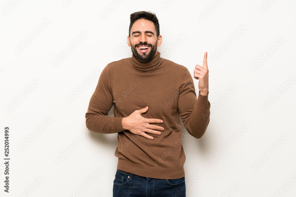Handsome man over white wall smiling a lot Handsome man over white wall smiling a lot