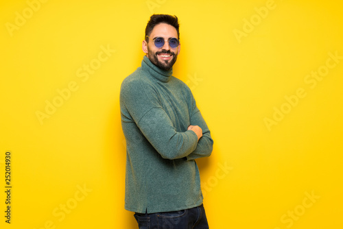 Handsome man with sunglasses with arms crossed and looking forward