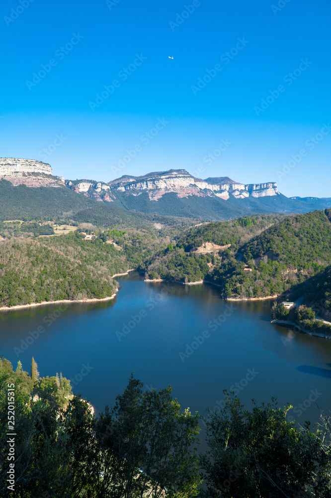 Sau Reservoir, Catalonia / Spain - Feb 24, 2019: Partial view of the swamp with a light aircraft flying over