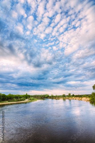 A river on a summer day with a cloudy sky above the horizon © Zayne C.