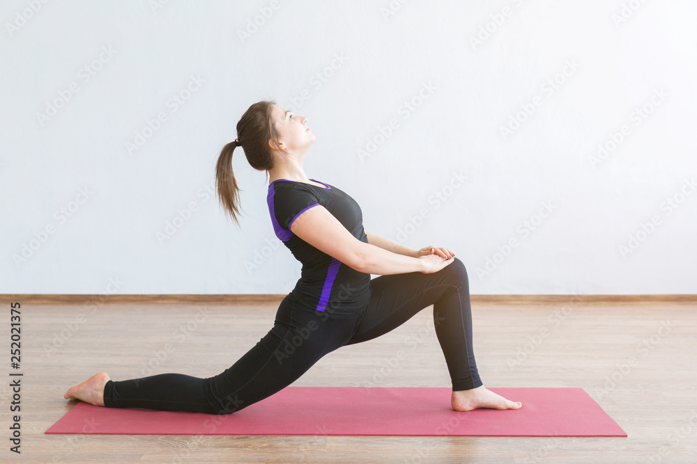 Young girl doing yoga. Performs stretching of the body. Young girl doing yoga. Performs stretching of the body.