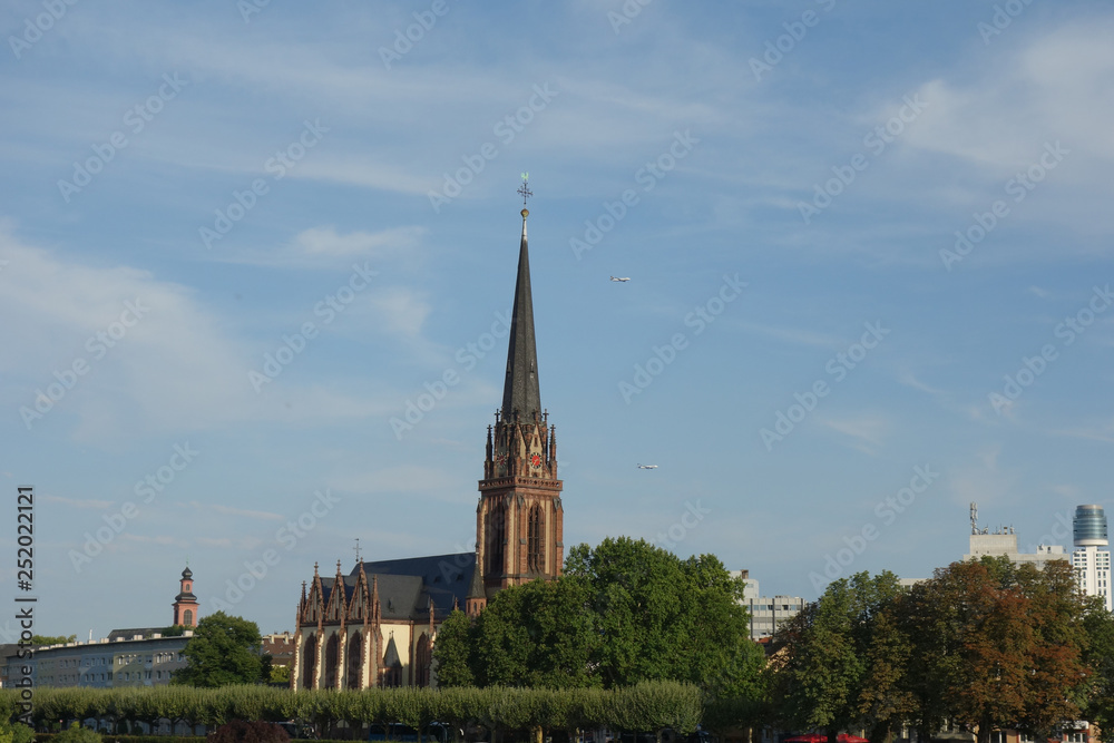 アイゼルナー橋から見たドライケーニヒ教会とドイツ騎士団教会の遠景とその背後を飛ぶ二機の旅客機