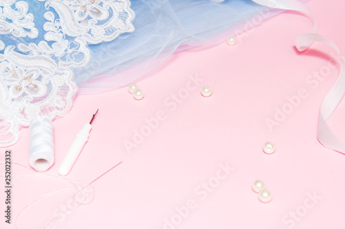 Tulle with lace and garment on a pink background. Sewing a wedding dress concept.