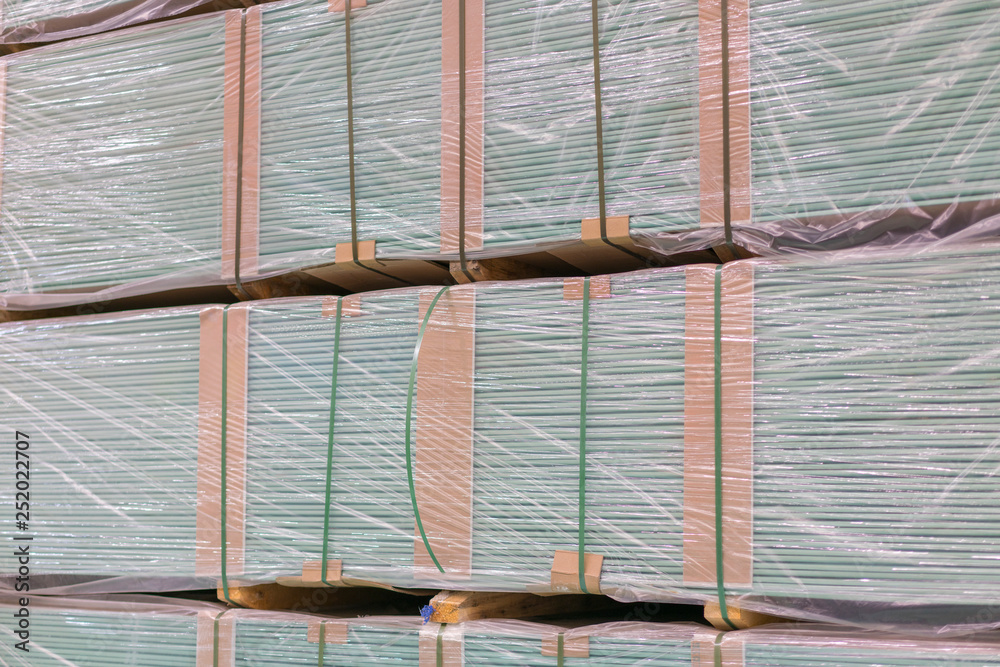 Fototapeta Gypsum plasterboard in the pack. The stack of gypsum board preparing for construction. Pallet with plasterboard in the building store. Construction Materials. Drywall warehouse