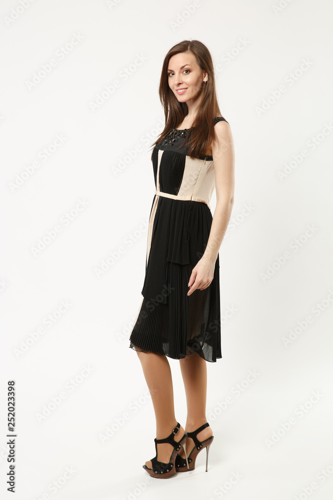 Full length photo fashion model woman wearing elegant evening dress black gown posing isolated on white wall background studio portrait. Brunette long hair girl. Mock up copy space. Side profile view. Full length photo fashion model woman wearing elegant evening dress black gown posing isolated on white wall background studio portrait. Brunette long hair girl. Mock up copy space. Side profile view.