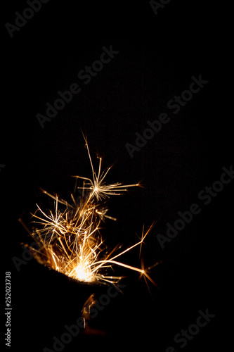   lose-up of fire flame with sparks from the gas pocket lighter in different shapes isolated on a black background.  concept of stopping and freezing the moment.