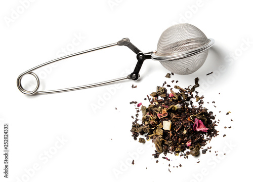 Tea strainer and a slide of herbal tea on a white isolated background. Close-up. Side view. photo