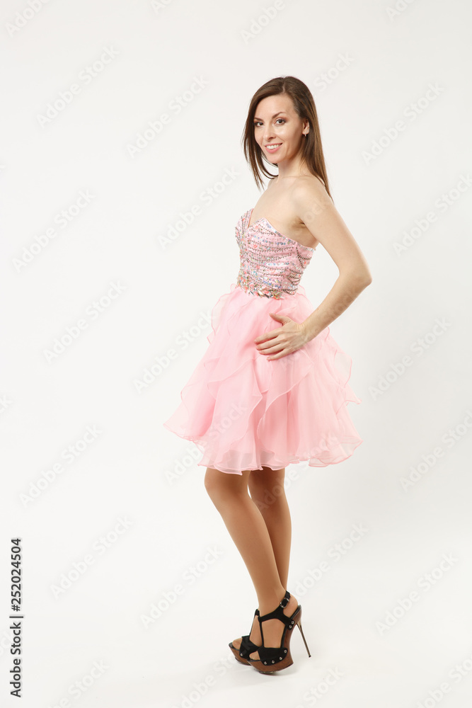 Full length photo fashion model woman wearing elegant evening dress pink gown posing isolated on white wall background studio portrait. Brunette long hair girl. Mock up copy space. Side profile view.