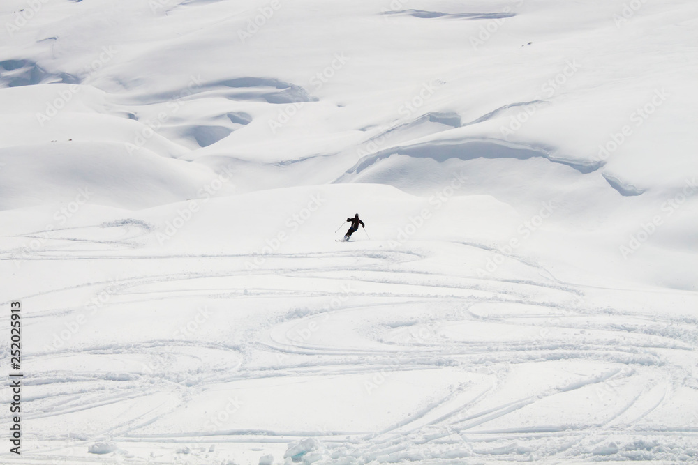 skier going down of a mountain covered of snow