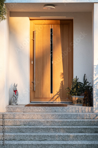Front door of modern house with Easter Bunny in front for decoration
