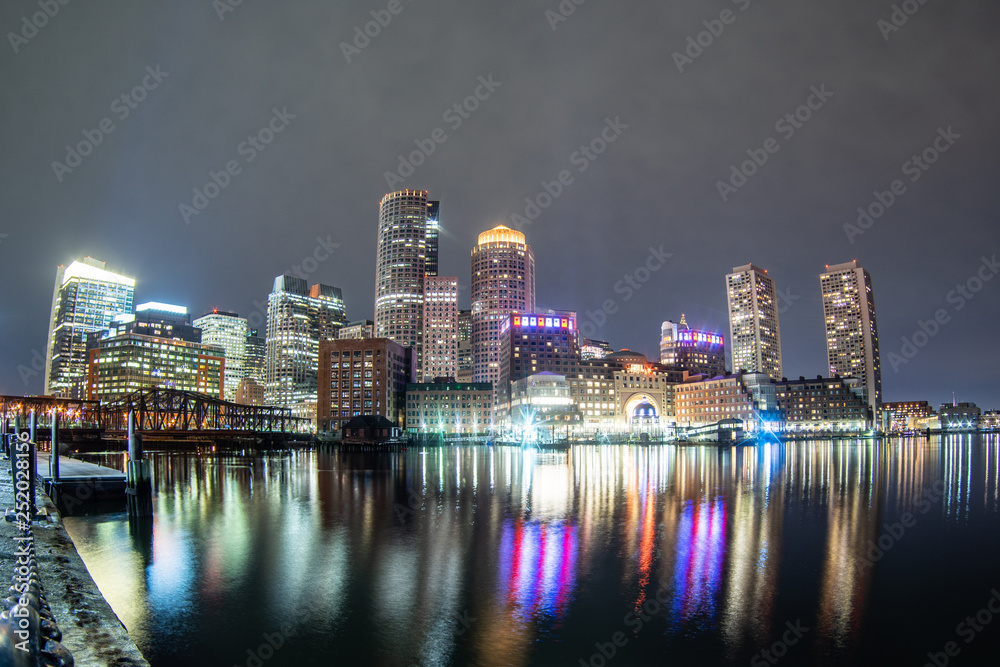 The Boston skyline and Fort Point Channel at night from Fan Pier Park