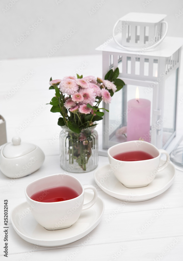 cups of fruit tea on wooden table decorated with flowers