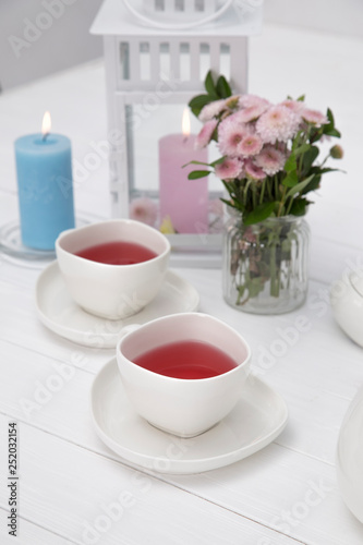 cups of fruit tea on wooden table decorated with flowers