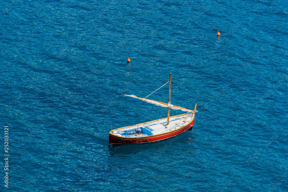 Small wooden boat with sail in the sea - Italy