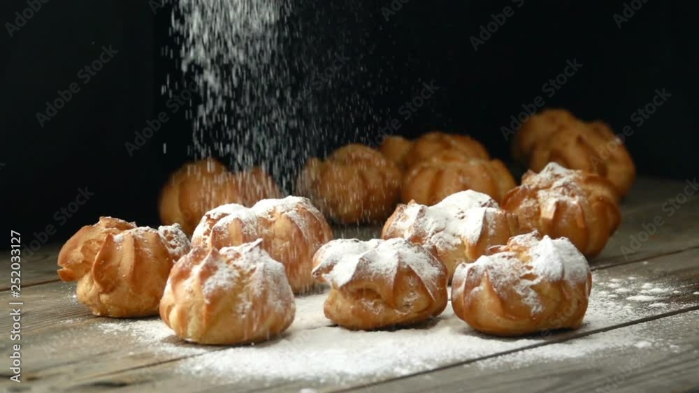 Sprinkling sugar powder over profiterole