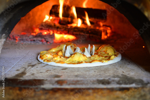Italian pizza preparing in wood-fired oven