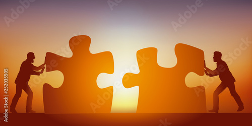 Concept du partenariat pour trouver une solution à un problème, avec deux hommes qui mettent en commun leurs intelligences, symbolisé par deux pièces de puzzle.