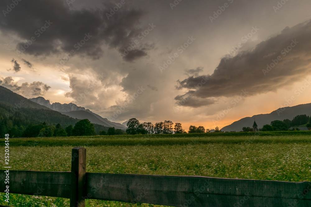 Fototapeta premium Storm clouds over the mountains near the town of Ratece in the Julian Alps, Slovenia