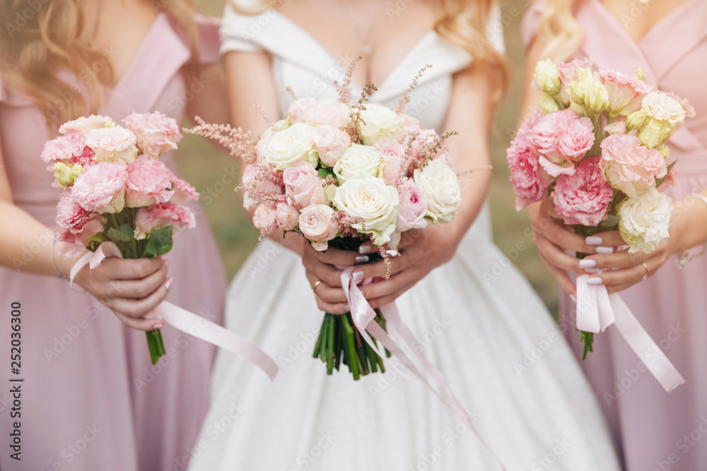 Wedding bouquet in hands. Beautiful bride with her pretty bridesmaids. Wedding bouquet in hands. Beautiful bride with her pretty bridesmaids.