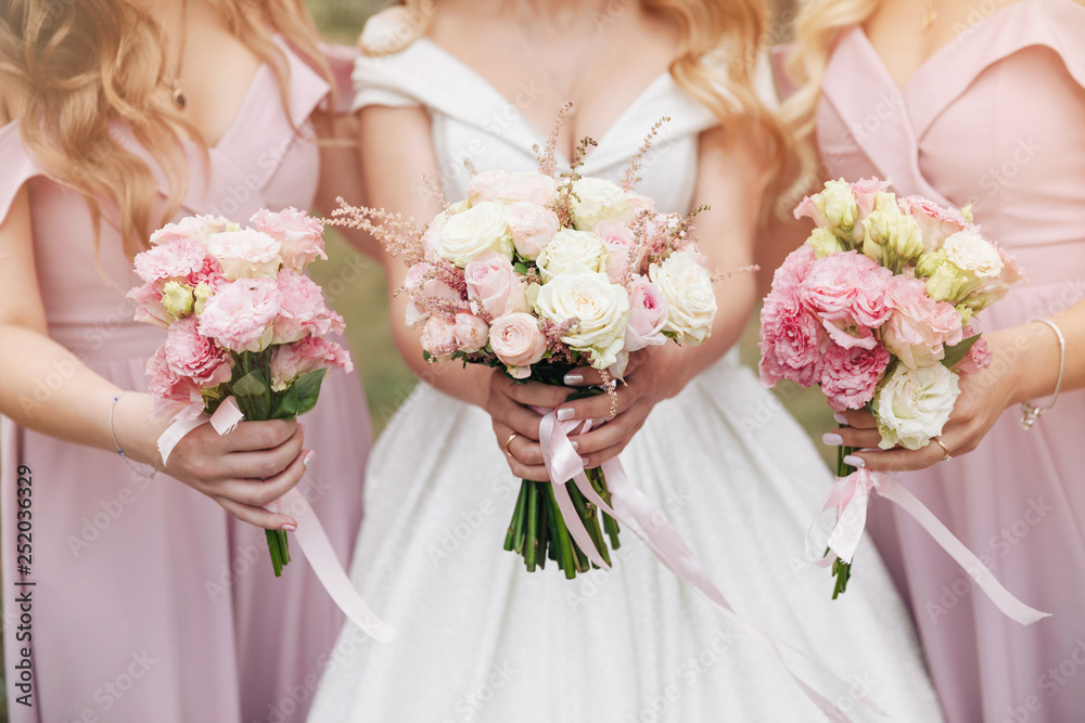 Wedding bouquet in hands. Beautiful bride with her pretty bridesmaids. Wedding bouquet in hands. Beautiful bride with her pretty bridesmaids.