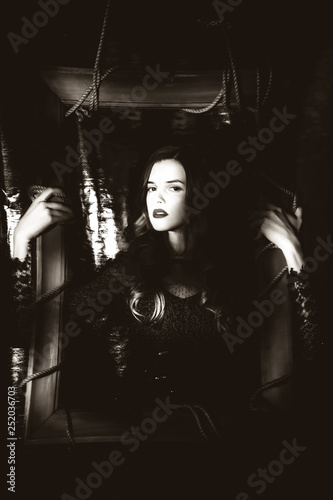 Beautiful girl in black dress on dark background