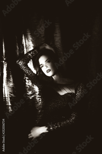 Beautiful girl in black dress on dark background