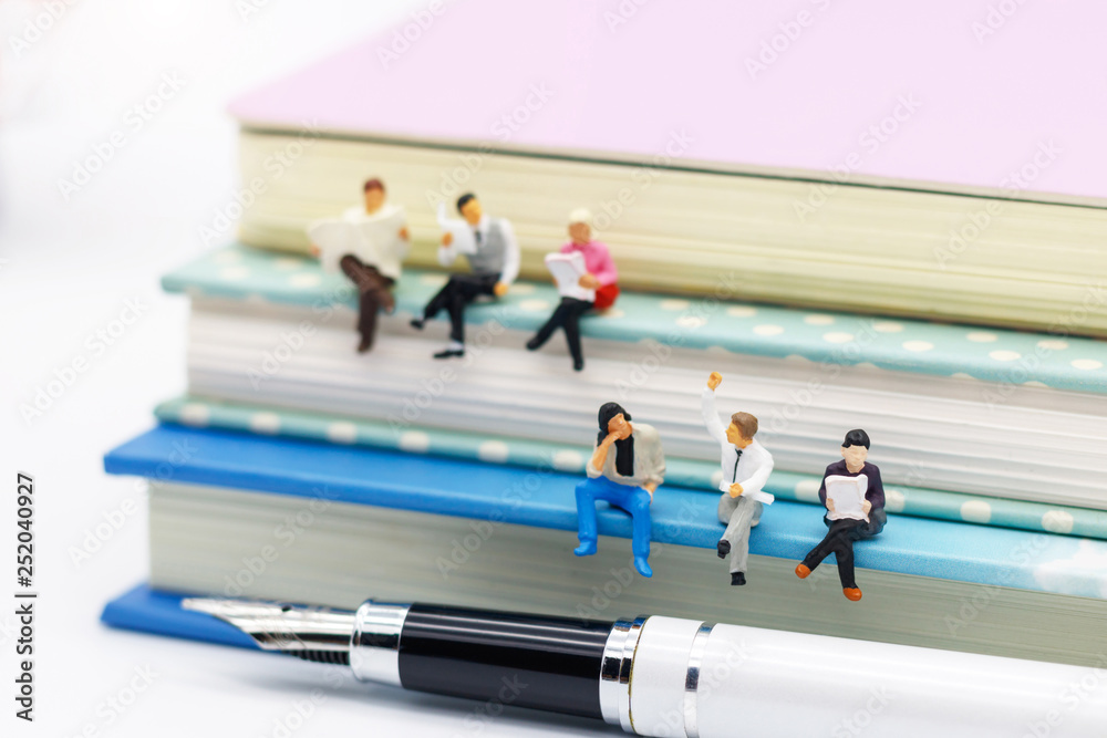 Miniature people: Business team reading book, education or business concept. Miniature people: Business team reading book, education or business concept.