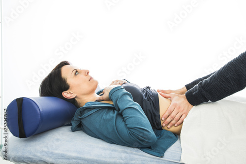 Physiotherapist massaging the belly of a young woman.Concept Physiotherapy © Rafa