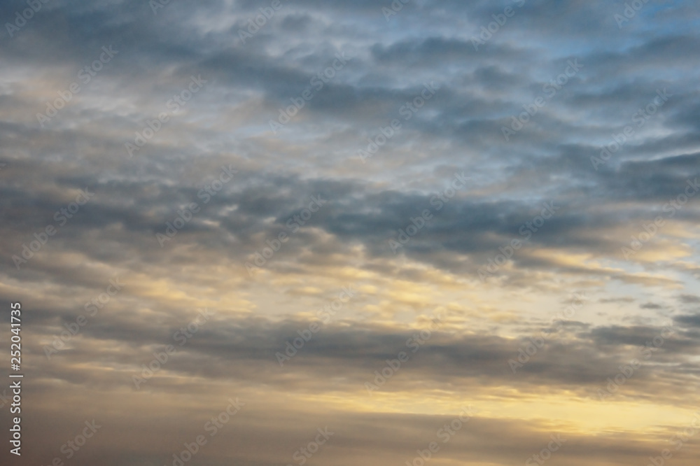 Lines of clouds on sky at sunset, alternation of light and dark stripes